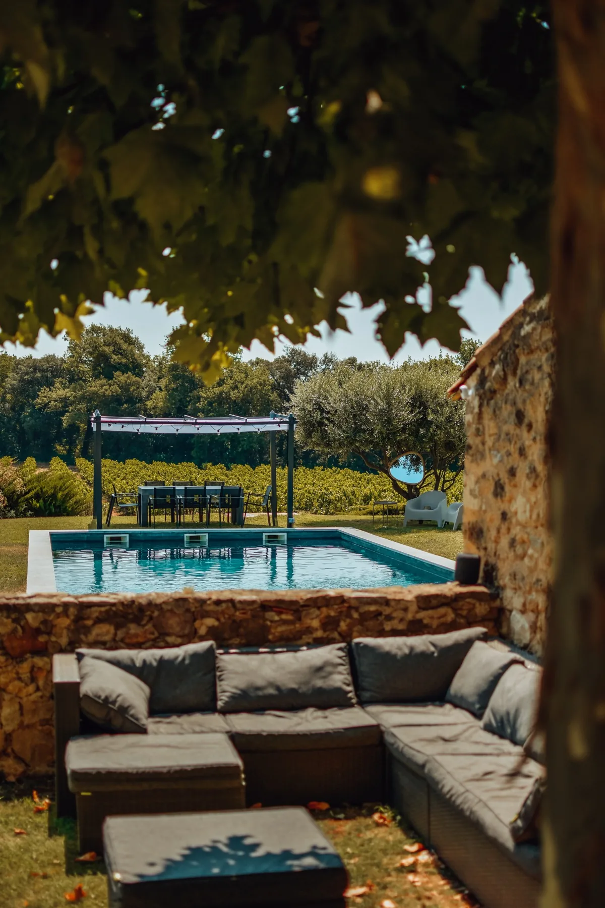 Salon extérieur ombragé avec vue sur la piscine